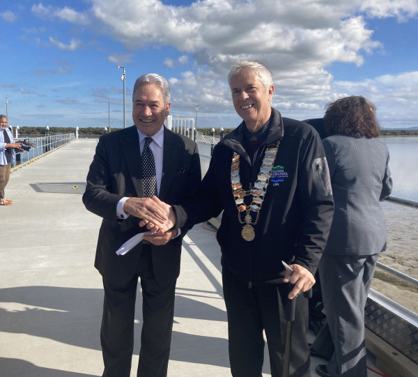 An image of two men, Deputy Prime Minister Winston Peters with Thames-Coromandel Mayor Len Salt (wearing mayoral chains), shaking hands at the opening of the new Kōpū Marine Precinct facilities